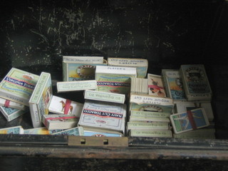A large metal tin containing a collection of loose cigarette cards