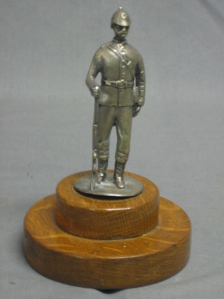 A plated figure of a standing 19th Century Infantryman, raised on a turned wooden base 7"