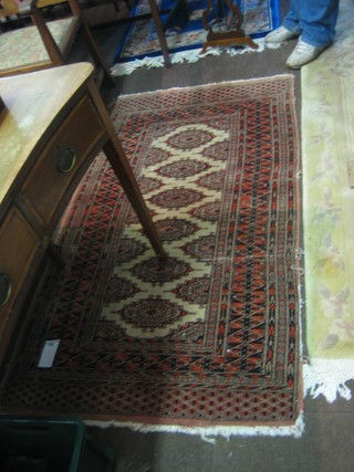 A Bokhara carpet with 6 stylised bells to the centre 64" x 35" (some wear)