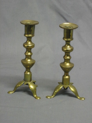 A pair of brass candlesticks, raised on 3 feet 7"