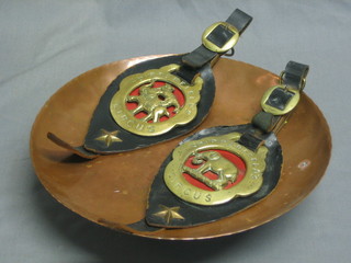 A circular hammered copper bowl and 2 Chipperfield's Circus horse brasses