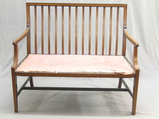 An Edwardian inlaid mahogany stick and bar back, chair back settee, raised on square tapering supports 40"