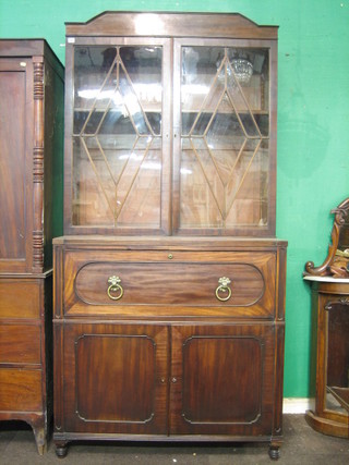 A Georgian mahogany secretaire bookcase, the upper section fitted adjustable shelves enclosed by an astragal glazed panelled door, the secretaire drawer revealing a well fitted interior, the base fitted a double cupboard enclosed by panelled doors fitted 1 long drawer above a cellarette drawer, raised on turned supports 43"