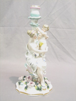 A 19th Century Continental porcelain candlestick in the form of a seated semi-naked lady with boy, raised on a floral encrusted base 14" (some minor chips to flower heads)