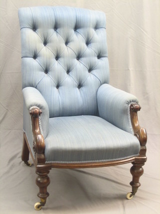 A Victorian mahogany armchair with scroll arms upholstered in blue buttoned material