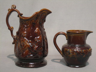 A 19th Century treacle glazed money box in the form of a seated gentleman, the reverse marked Money taken here (slight chip to reverse) 4" and 2 treacle glazed  jugs 5" and 7"