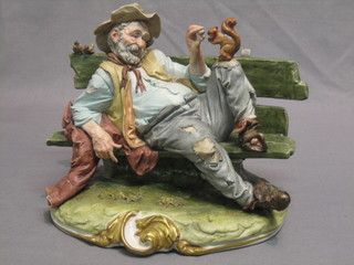 A Capo di Monte figure of a reclining tramp with squirrel 8"