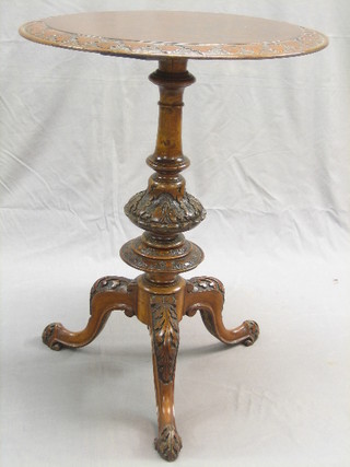 A Victorian circular walnut wine table raised on a carved column and tripod base 20"