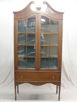An Edwardian inlaid mahogany display cabinet with broken pediment, the interior fitted shelves enclosed by astragal glazed panelled doors, the base fitted 1 long drawer, raised on square tapering supports ending in spade feet 36"