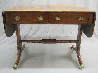 A 19th Century mahogany sofa table with crossbanded top fitted 2 drawers, turned stretcher to the base, raised on splayed supports ending in brass caps and castors 36"