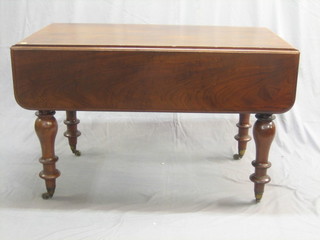A Victorian mahogany extending drop flap dining table with 1 extra leaf, raised on turned supports 44"