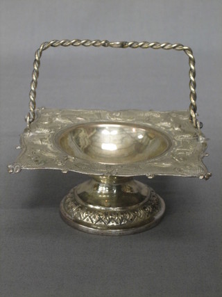 An Eastern embossed silver bon bon dish with swing handle, raised on a circular spreading foot 2 ozs