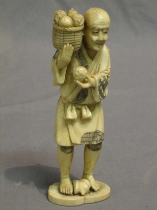 A 19th Century carved ivory figure of a standing gentleman with basket of fruit 6"