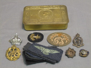 A Princess Mary gift tin containing an RAF cap badge, Royal Army Medical Corps cap badge, Royal Army Service Corps shoulder title, British Legion badge, Chief Super Intendant's Crown, 6 RAF cloth albatrosses together with 2 other cloth badges