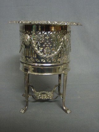 A circular pierced silver plated soda siphon holder with cast border, raised on 4 feet 9"
