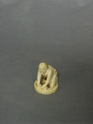 A carved ivory figure of a seated man 1"
