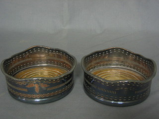 A pair of pierced silver plated bottle coasters