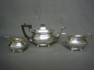 An Edwardian silver 3 piece tea service of oval form with demi-reeded and armorial decoration comprising teapot, twin handled sugar bowl and cream jug Sheffield 1901, 43 ozs