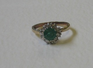 A 9ct gold dress ring set an emerald supported by diamonds