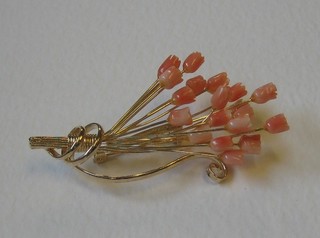A gilt metal and coral spray brooch in the form of flowers