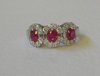 A lady's 18ct white gold dress ring set 3 large oval cut rubies supported by diamonds (approx. 1.04/1.3ct)