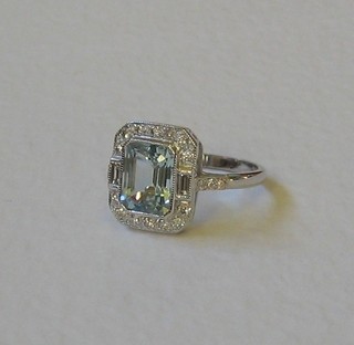 A lady's 18ct white gold dress ring set an rectangular cut aquamarine surrounded by numerous diamonds