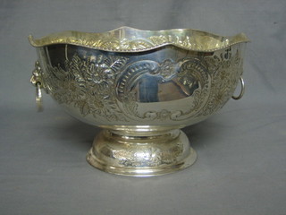 A circular embossed silver plated punch bowl with wavy border and lion mask handles, raised on a spreading foot 13"