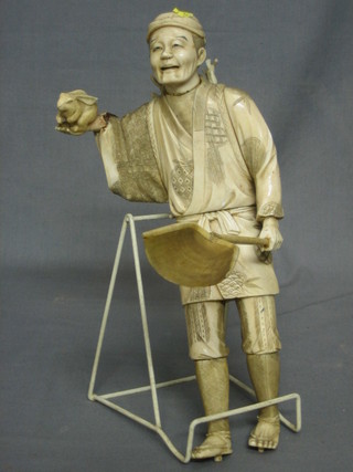 A Japanese carved ivory figure of a standing gentleman with rabbit and shovel 12"