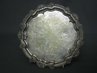 A circular engraved silver plated salver with bracketed border, raised on bun feet 8"
