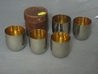 5 Edwardian graduated silver tumbler cups contained in a leather carrying case