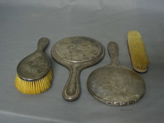 A silver backed 3 piece dressing table set comprising handmirror, hair brush and clothes brush together with a silver hand mirror