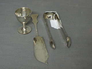 2 pairs of sugar tongs, a silver fish knife and a silver egg cup