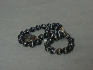 A string of striped onyx beads together with a matching necklace