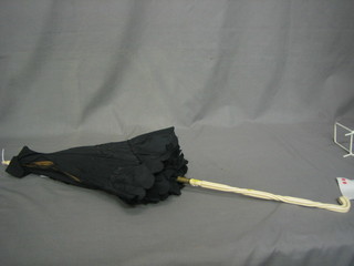 A parasol with carved ivory handle
