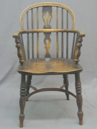 An 18th/19th Century elm Windsor stick back chair with solid elm seat and cow horn stretcher, raised on turned supports