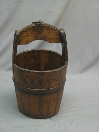 An Eastern coopered bucket with iron banding
