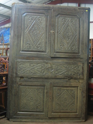 A Victorian carved oak corner cabinet secretaire, the upper section fitted shelves enclosed by panelled doors, the base fitted a fall front revealing a well fitted interior above double cupboard 51"