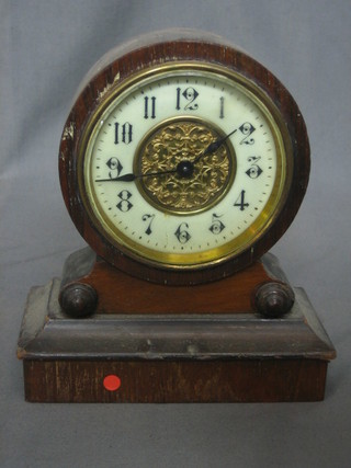 An Edwardian 8 day bedroom clock with Arabic numerals contained in an arch shaped walnut case
