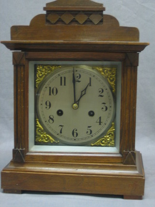 A striking bracket clock with silvered dial and Arabic numerals contained in a walnut case