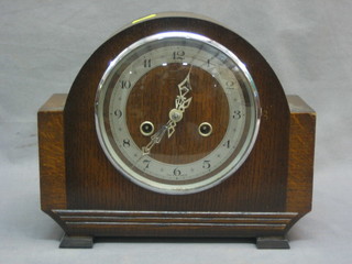 A 1930's striking mantel clock with silvered dial contained in oak arch shaped case by Enfield