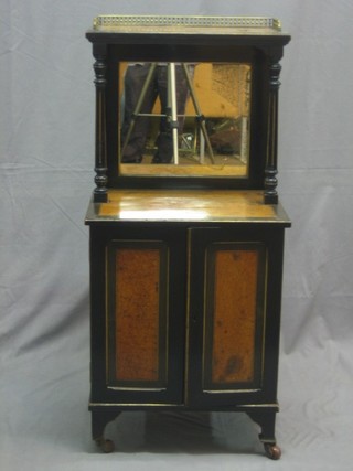 A Victorian Amboyna and ebonised  music cabinet with raised back and pierced gilt metal three quarter gallery, having a recess with bevelled plate mirrored panel to the back, the base fitted a cupboard enclosed by panelled doors by Edwards & Roberts, raised on bracket feet 18 1/2"