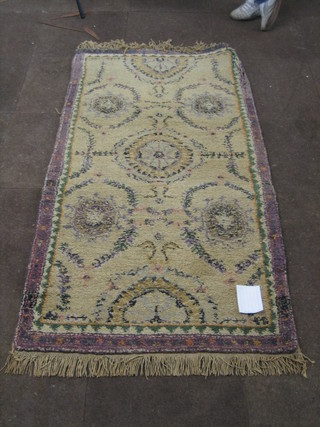 A white ground Indian rug with floral and swag decoration  70" x 37"