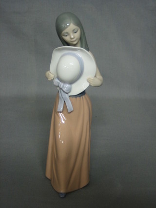 A Lladro figure of a standing girl with bonnet, the base incised 36, 9"