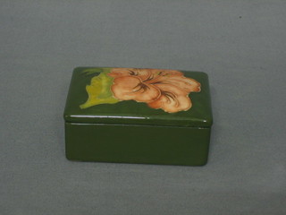 A Moorcroft rectangular green glazed Camellia pattern jar and cover, the base impressed Moorcroft England, 4"