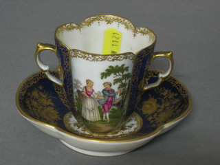 A Dresden style twin handled chocolate cup with blue and gilt banding, decorated romantic scenes, the base with AR cypher complete  with matching saucer