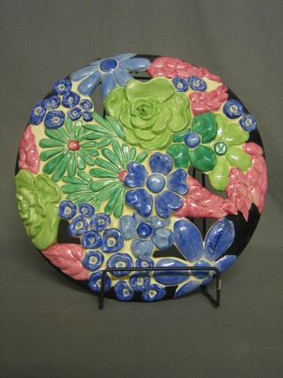 A Clarice Cliff pierced pottery wall plaque of floral form, with painted Clarice Cliff signature to the front, the reverse marked Bizarre by Clarice Cliff 13" diameter