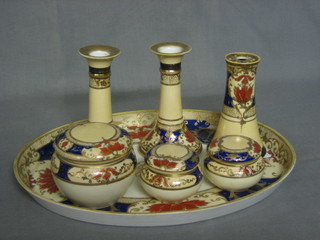 A Noritake 7 piece porcelain dressing table set comprising oval tray 13", pair of candlesticks, 3 circular trinket boxes and a hat pin stand