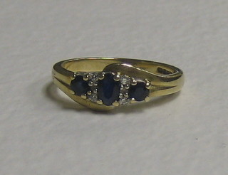 A lady's 9ct gold dress ring set 3 sapphires supported by diamonds