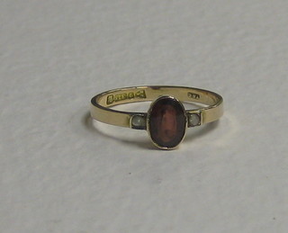 A lady's Edwardian 9ct gold dress ring set a garnet and 2 pearls