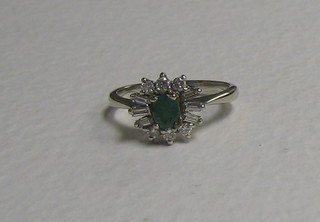 An 18ct gold dress ring set an emerald supported by 6 baguette cut diamonds and 6 circular cut diamonds